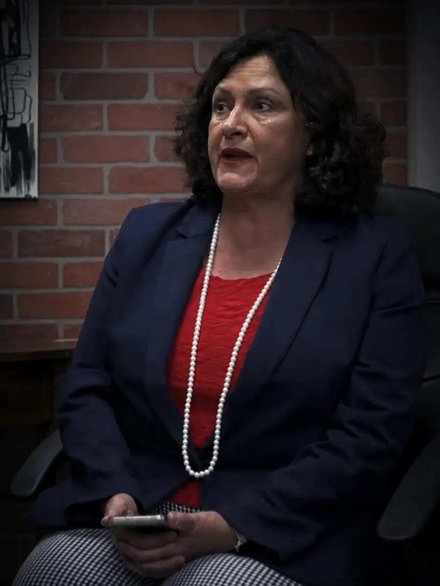 Judge Mavel Ruiz seated during an interview against a brick wall.